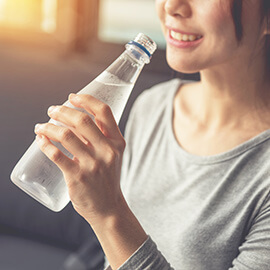 Closeup of a woman drinking bottle of water
